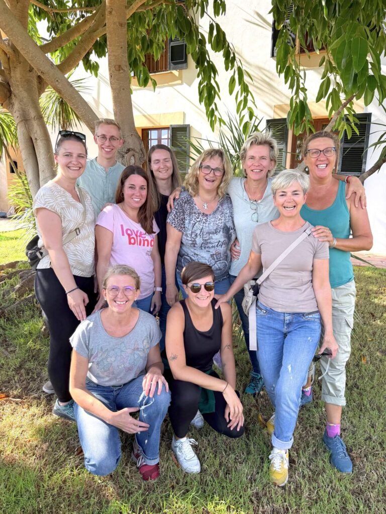 Gruppe von Frauen lächelt zusammen.