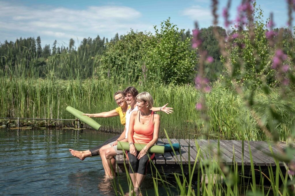 Drei Personen am Wasser entspannen.