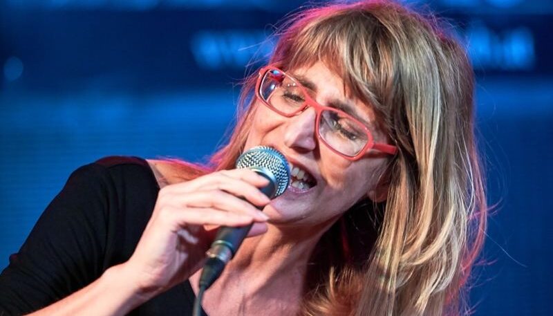 Frau singend mit Mikrofon in der Hand