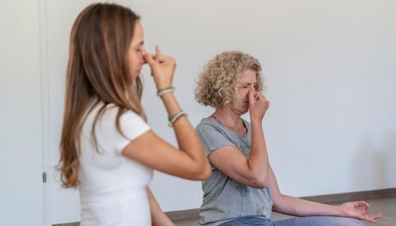 Zwei Frauen praktizieren Atemübungen.