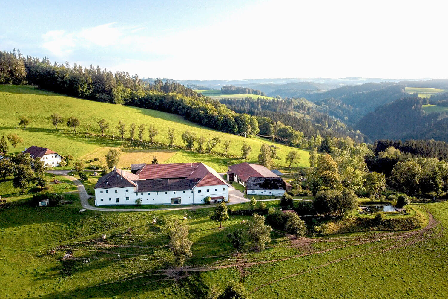 Landschaft mit Bauernhof und Hügeln